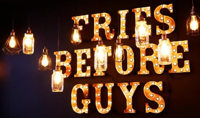 "Fries before Guys" Leuchtreklame im Frittenwerk